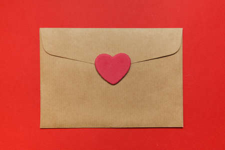 Top view. Empty envelope, sticker Heart on red background. copy spaceの写真素材