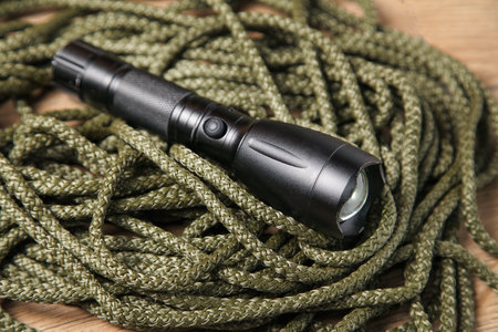 Khaki rope and black flashlight, Concept survival first aid, tools, Mountaineering Safety Equipment.の写真素材