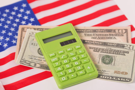 USA American flag, calculator and dollars. Calculating expenses concept. inflation, economic, income, budget, financial planningの写真素材