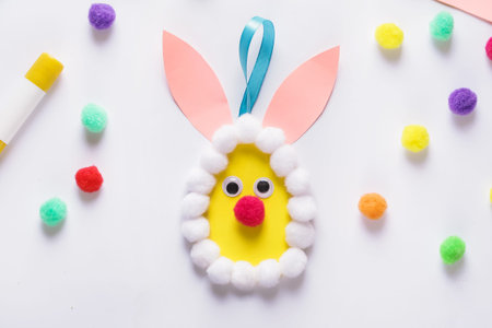 Step by step instruction. Making of handmade Easter egg from pompons. DIY Kids Craft concept. Step...
