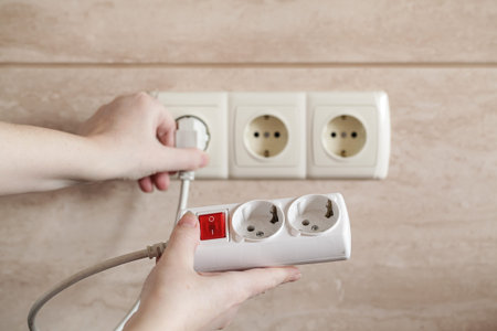 Woman plugs in the electric charger. Energy savings, energy efficiency