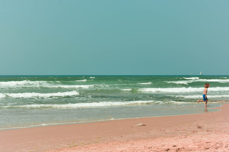 Kid running on the beach during a sunny dayのeditorial素材