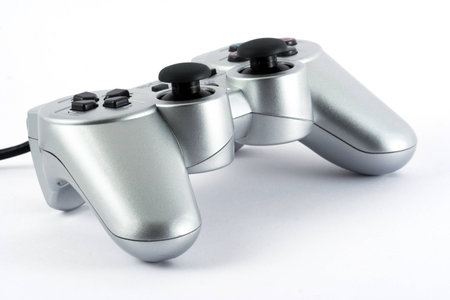 A silver colored game pad on white background