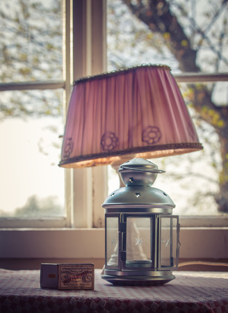 Matches and a lamp in front of a windowのeditorial素材