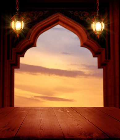 Ramadan Kareem background..Mosque window with shiny crescent moon and wooden tableの写真素材