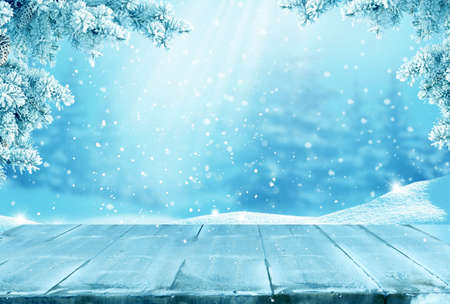 Merry christmas and happy new year greeting background with table .Winter landscape with fir tree branchの写真素材