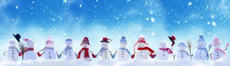 Merry Christmas and happy New Year greeting card with copy-space.Many snowmen standing in winter Christmas landscape.Winter backgroundの写真素材