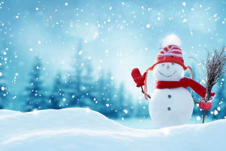 Happy snowman standing in christmas landscape.Snow background.Winter fairytale.Merry christmas and happy new year greeting card with copy-space.の写真素材
