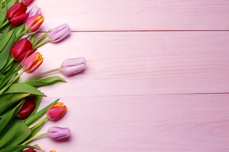 Spring flowers composition on the wooden background.Top view colorful tulips on a wooden surface. Copy space.の写真素材