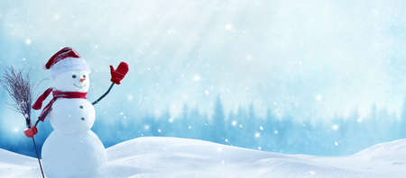 Cute smiling snowman with red scarf and hat with a broom in his hand.Winter fairytale.Greeting card with copy-spaceの写真素材