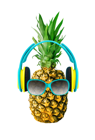 Funny pineapple with glasses and headphones. Tropical fruit isolated on white background. Tropical food design elementの写真素材