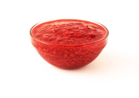 Side view of raspberry jam in glass transparent bowl isolated on white backgroundの写真素材