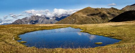 Blue lake at mountains ridge background at autumn sunny dayの写真素材