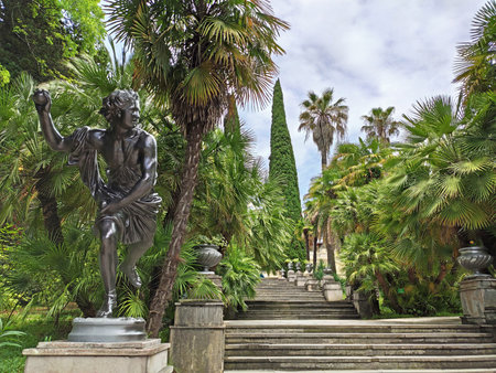 Sochi, Russia - June 21, 2020: Statue at staircase and subtropical trees and palms background in Sochi Arboretum. Famous tourist place in Russiaのeditorial素材