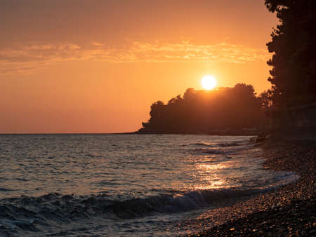 Panoramic view of beach with sunset and sea wavesの写真素材