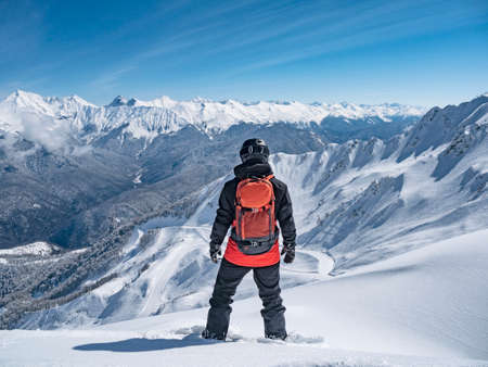 Back view of snowboarder at mountains background in ski resort of Krasnaya Polyana, Russiaの写真素材