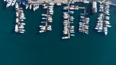 Top aerial view of fishing boats and luxury yachts anchored in sea port at blue water backgroundの写真素材
