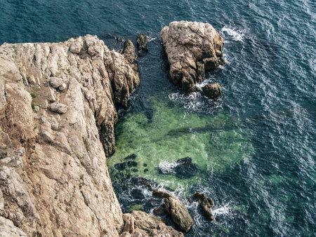 Top aerial view of blue sea water and rocky cliffの写真素材