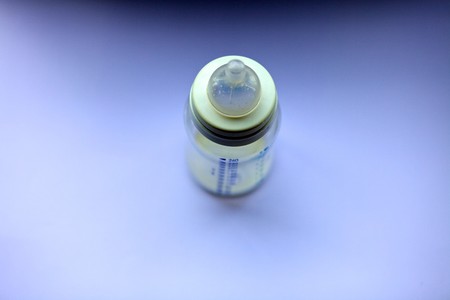 Blurry milkbottle with focus on the nipple.の写真素材