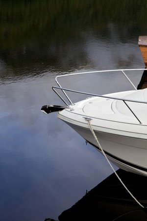 Bow of a small yacht with reflections in the water.の写真素材