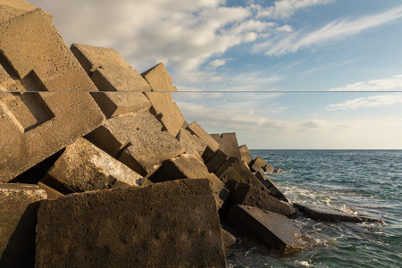Breakwater blocks in the port of Puerto Rico, Gran Canaria, with the Atlantic Ocean in the backgroundの写真素材