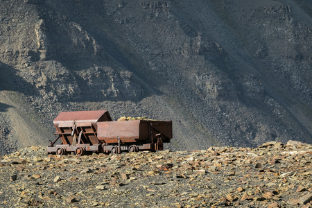 Old abandoned coal wagons, used for the coal mining industry, mountain background Longyear valley, Svalbard Norway. Arctic landscape.の写真素材