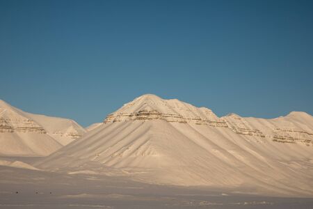 Beautiful arctic winter landscape with snow covered mountains on Svalbard, Norwayの写真素材