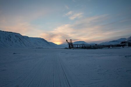 Snowmobile tracks on the sea ice, leading to Pyramiden harbour. Abandoned Soviet Russian settlement in Svalbard, Norway.の写真素材