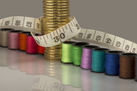 Tailoring costs represented by coins, threads and metersの写真素材