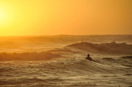 Man relaxing into sea at sunsetの写真素材