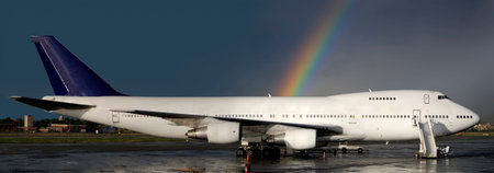Aircraft parked with a rainbow behindの写真素材