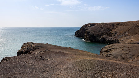 Rocky coastline in volcanic landscape with blue sky on a sunny day near Playa Mujeres, Lanzarote,...