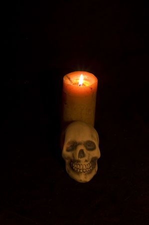 Candle and skull against blackの写真素材