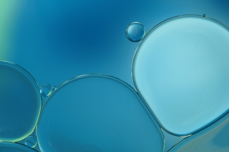 oil drops in water with blue backgroundの写真素材