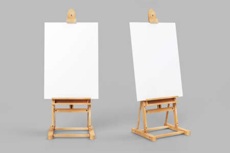 Easel stand board with blank white poster isolated. Wooden easel art painting paper frame stand or poster.White easel stands next to bright gray wall, 3d rendering.の写真素材