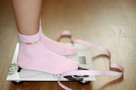 Woman on scale with pink tape measure, dietの写真素材