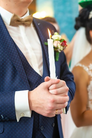 Bride and groom holding the candles. Close up.の写真素材