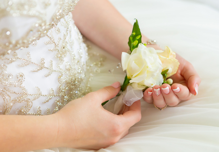 Bride's hands with a bouquet for the groom.の写真素材