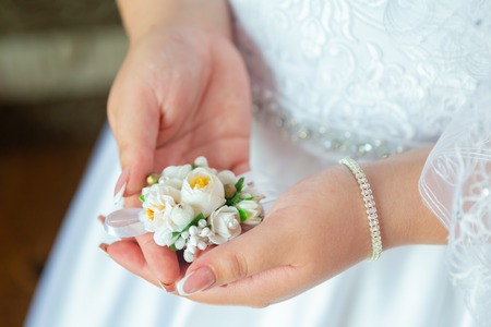 Bride's hands with a bouquet for the groom.の写真素材