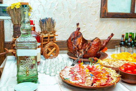 A vibrant table is adorned with delicious food, including pasta, meats, and drinks, perfect for a festive celebration among loved ones.の写真素材