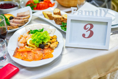 A beautifully arranged family table features a seafood platter along with various appetizers and a...