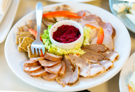 A Delicious and Colorful Platter of Cold Cuts With Fresh Vegetables and a Dip on a White Plateの写真素材