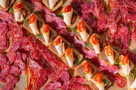 Delicious Appetizer Spread Featuring Savory Meats and Fresh Vegetables on a Wooden Platter