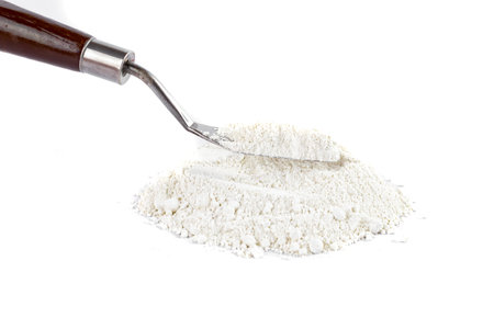 White Powder With a Metal Spatula on a Clean Surface in a Bright Settingの写真素材