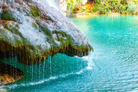 Adventurers Rappel Down a Stunning Waterfall in a Rocky Landscape Surrounded by Lush Greeneryの写真素材