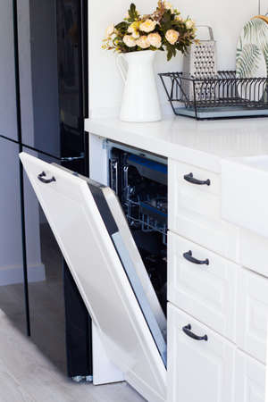 modern built-in dishwasher in beautiful white kitchen with flowers. beautiful interior. no people High quality photoの写真素材