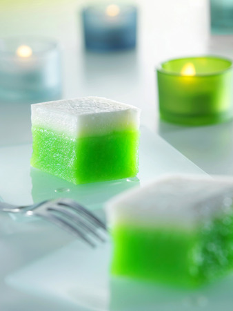 Malaysia food-Two pieces of kueh talam with a fork and candles by the sideの写真素材