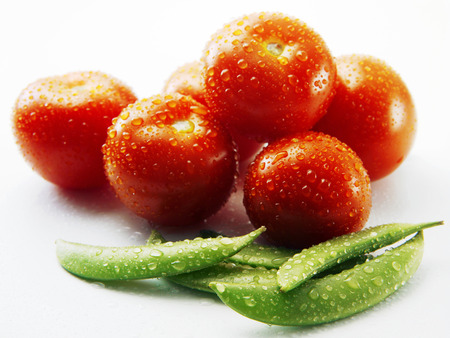 Tomatoes and green peasの写真素材
