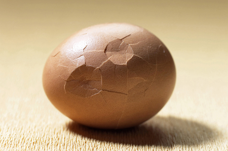 A cracked egg on the tableの写真素材