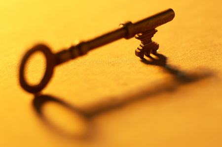 Close-up picture of a house key and its shadowの写真素材